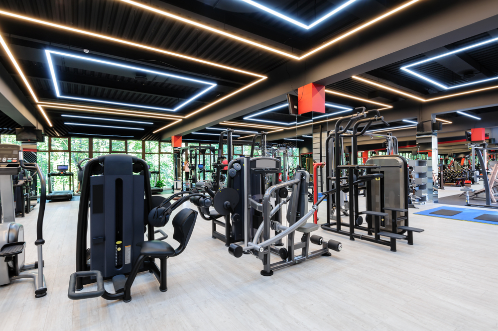 Modern fitness gym interior showcasing various workout machines and equipment, emphasizing a clean, well-lit environment for fitness enthusiasts and clients seeking maintenance services.