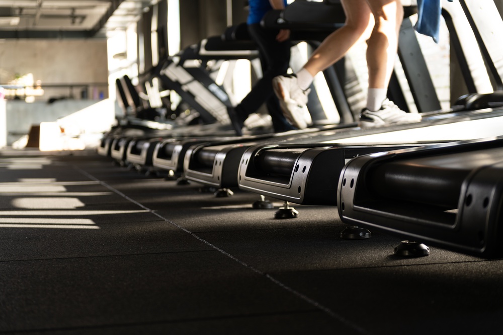 Treadmills in a gym setting with individuals exercising, highlighting the importance of preventive maintenance for commercial fitness equipment.
