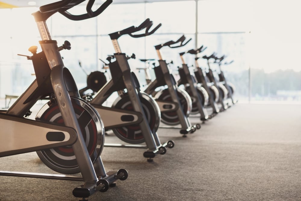 Row of stationary exercise bikes in a well-lit gym, highlighting the importance of fitness equipment maintenance and repair services in Maryland.